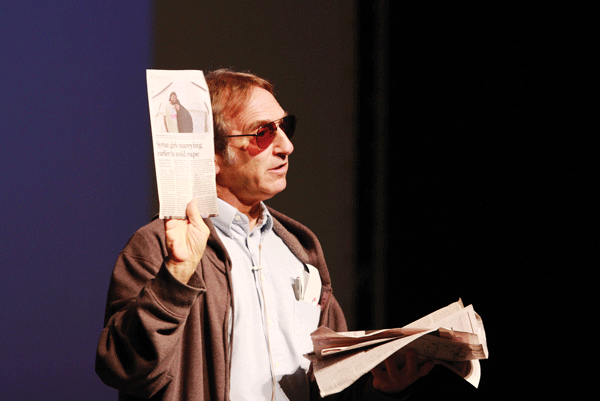 Photo by Amy Price | Dr. Rick Halperin shows the audience news articles about human rights violations.