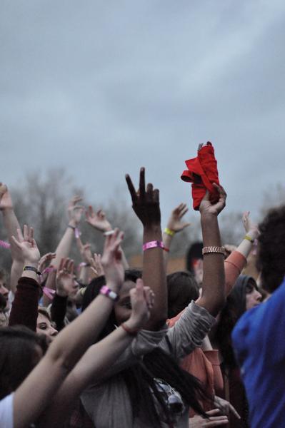 Photo by Adriana Salazar | A crowd of people at 35 Denton wave their hands in the air during a concert despite dreary weather conditions. 