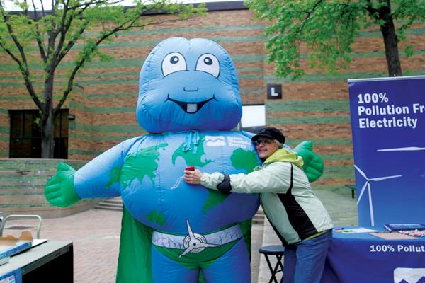 Brookhaven librarian Lois Wagenseil poses with an inflatable earth super hero.