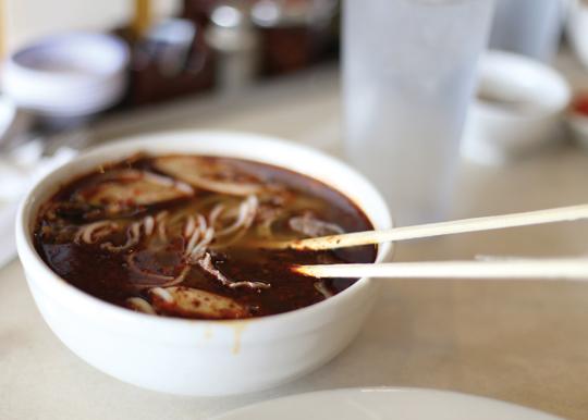 Photos by Scott Mitchell | A bowl of fiery hot bun bo hue steams after being freshly served from the kitchen. 