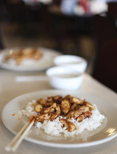 Photos by Scott Mitchell |  A plate of white rice soaks flavor from marinated chicken. 