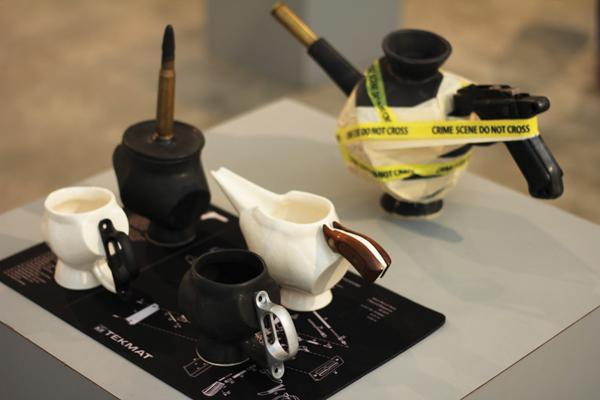 student Amy Titus' third-place ceramic and mixed media piece, "Gun Debate Over Coffee," lies among the Juried Student Art Exhibition held May 8. 