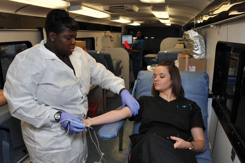 Photo by Scott Godbey | Carter BloodCare phlebotomist Chelseay Pannell evaluates Brookhaven College student Danielle Garrick’s veins in preparation to donate blood at the Carter BloodCare mobile unit Sept. 11 in S Building parking lot.  