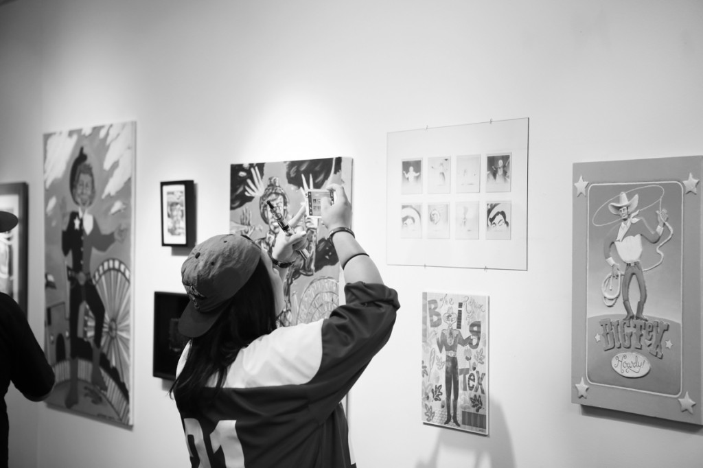  A Brookhaven student takes a photo of a series of Poloroids, taken by Brookhaven communications professor Daniel Rodrigue, shown in “The Return of Big Tex” in the Atrium Gallery