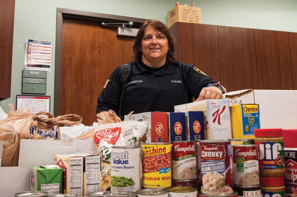 Photo by Scott Godbey | Officer Vikki Ethington stands behind the mountain of donated food items for the campus food pantry.  