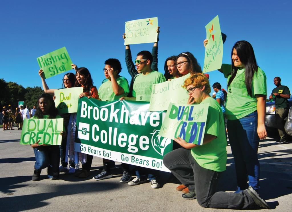  Brookhaven College Rising Star scholars and dual-credit students represent the school at the W.T. White High School homecoming parade with bright neon green shirts and signs.