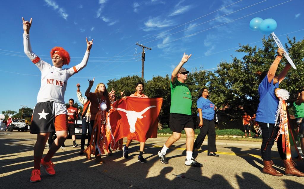  The W.T. White Longhorns march in the parade wearing their school colors and holding a University of Texas flag. 