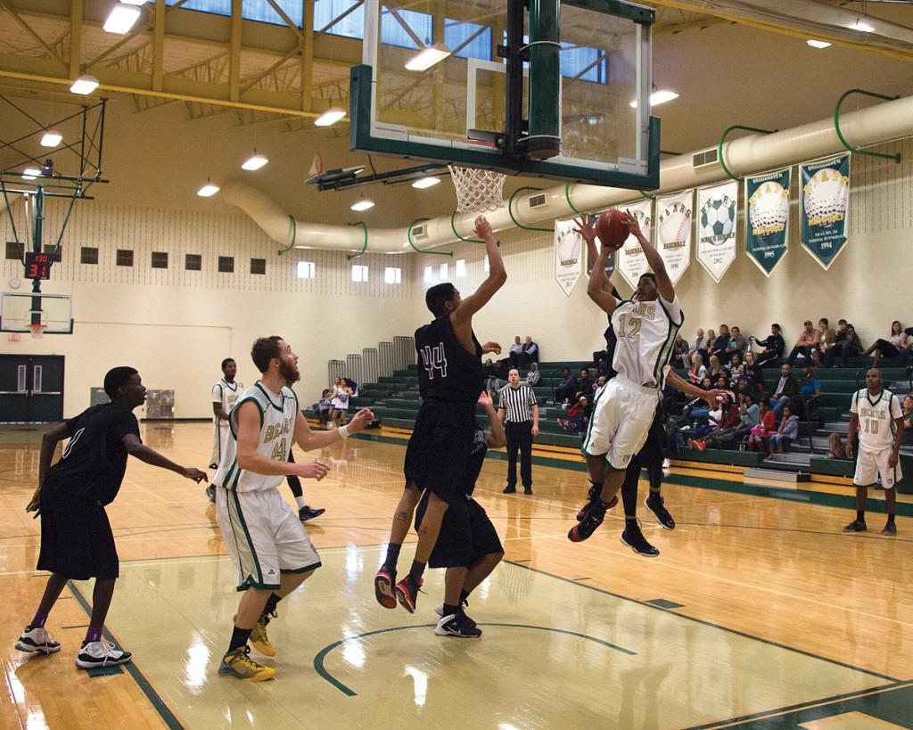 Laquin Turner (#30) drives into a congested lane and adjusts his layup acrobatically to avoid the reach of Richland College’s defense