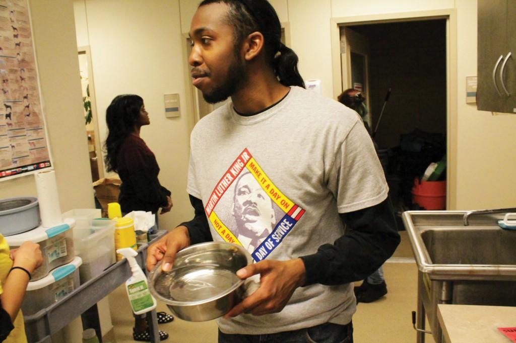 Photo by Ravin Lee | Brookhaven student and MLK Day of Service volunteer Kevin Lee delivers a fresh bowl of water to a kennel at the Farmers Branch Animal Adoption Center Jan. 20.