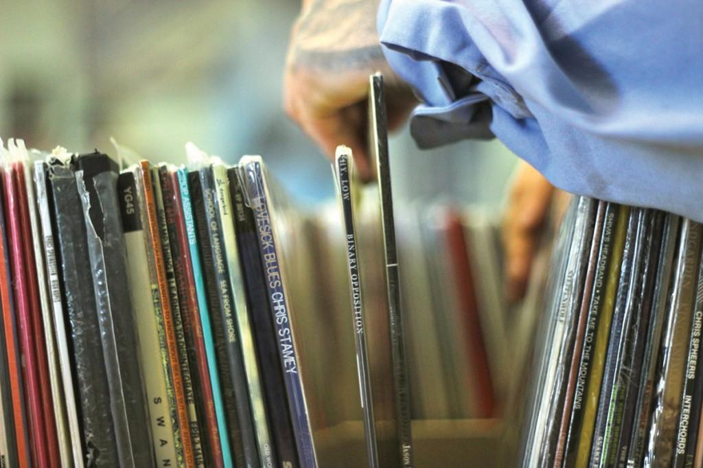 Photo by Wanz Dover | A customer shuffles through stacks of vinyl records. 
