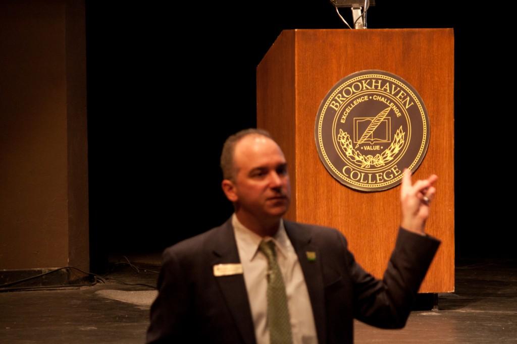 Photo by Nicholas Bostick | Brookhaven College President Dr. Thom Chesney points to the Brookhaven logo during the Sept. 2 convocation speech in the Performance Hall, where he talked about the advantages of attending community college.