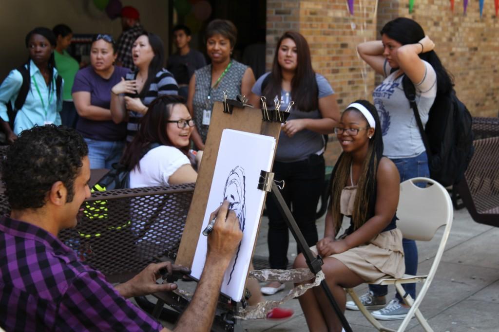 Photo by Willie R. Cole | Caricature artist Sami Aly draws his parody illustration of Brookhaven College student Desiree Island as students line up to have their portraits sketched at the Welcome Back Carnival Sept. 10 in the Commons Courtyard.