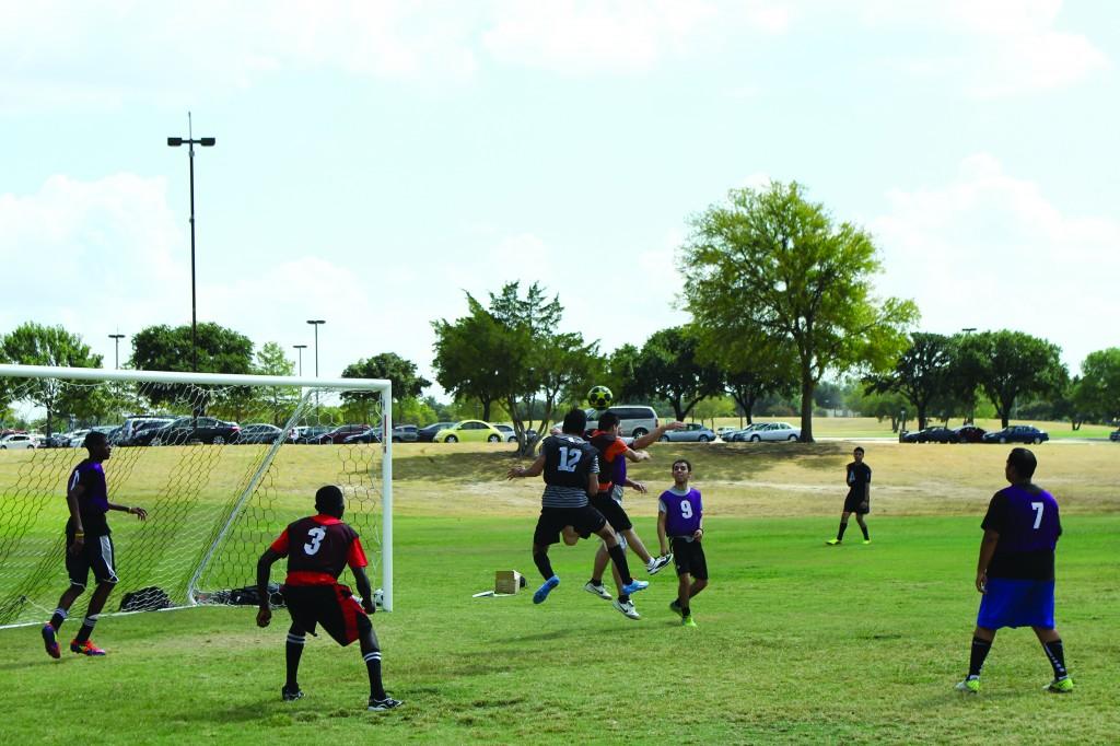 Photo by Willie R. Cole | Two intramural soccer players jump for a header as teammates look on.