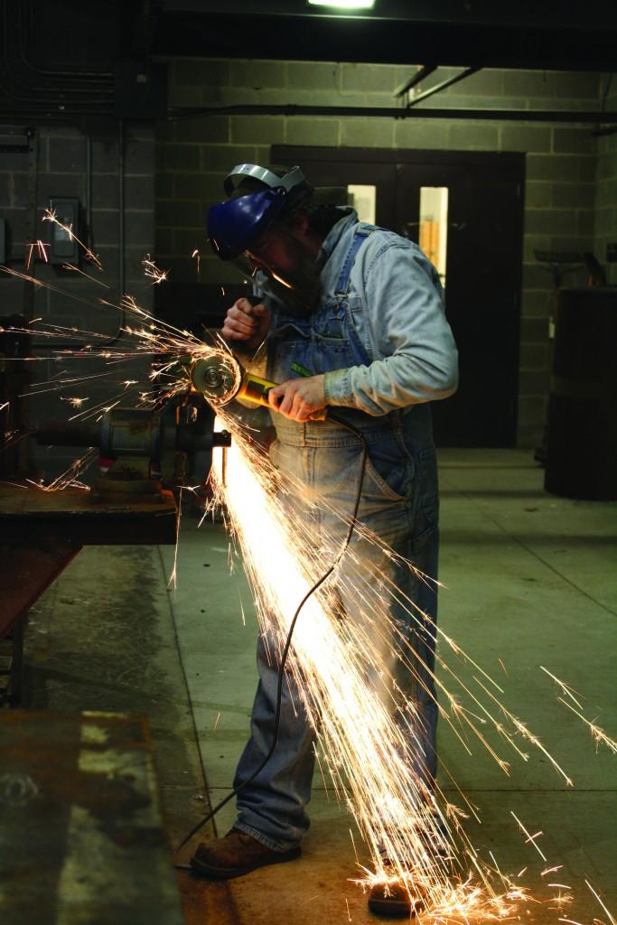 Instructor Kelly Kring prepares the metal for students’ projects.