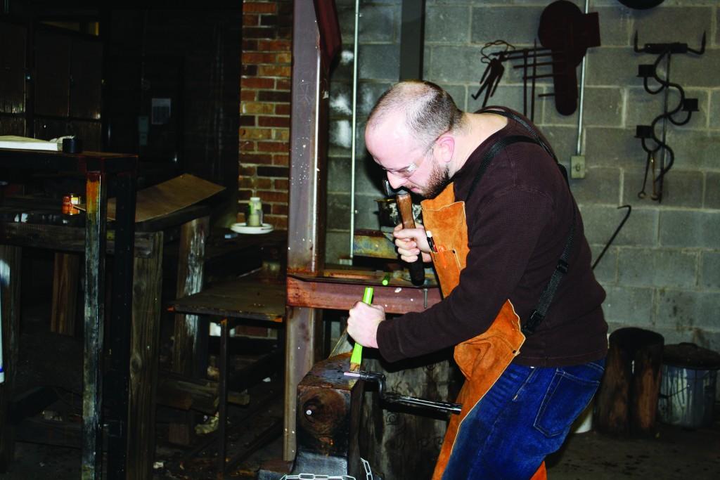 Photos by William De La Cruz | Adam Elliott uses a hammer and anvil to shape his flint striker.