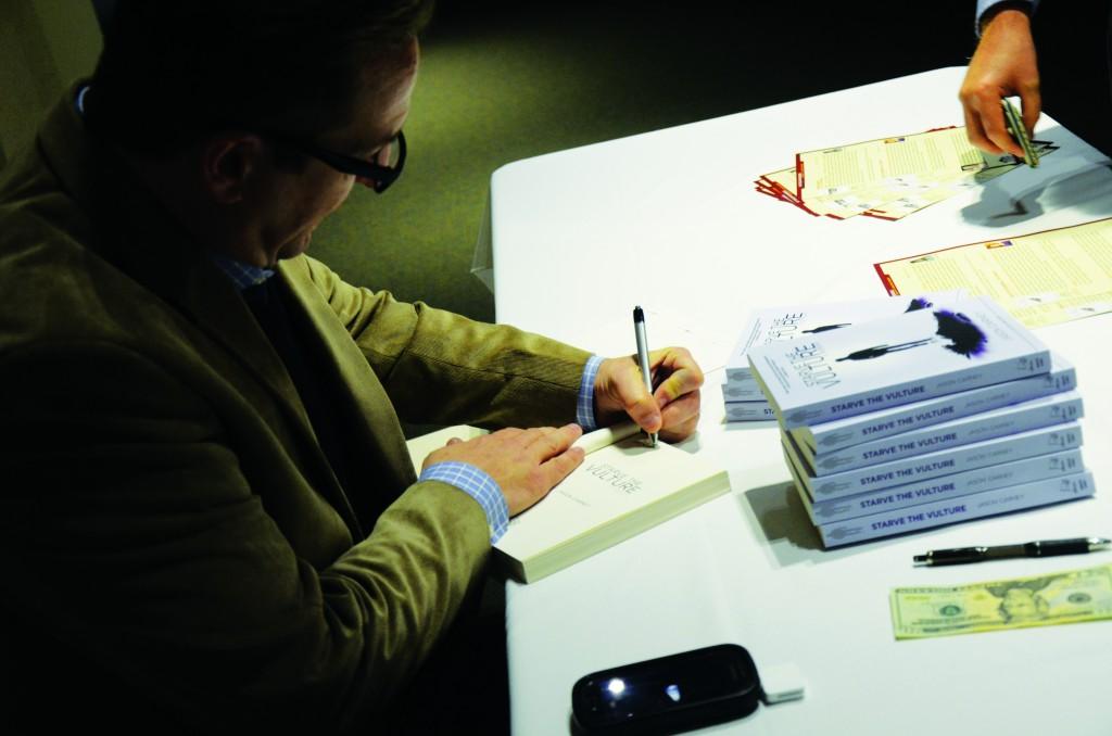 Photo by Travis Baugh | Brookhaven English professor and poet Jason Carney signs a copy of his memoir, “Starve the Vulture,” in the Performance Hall lobby.