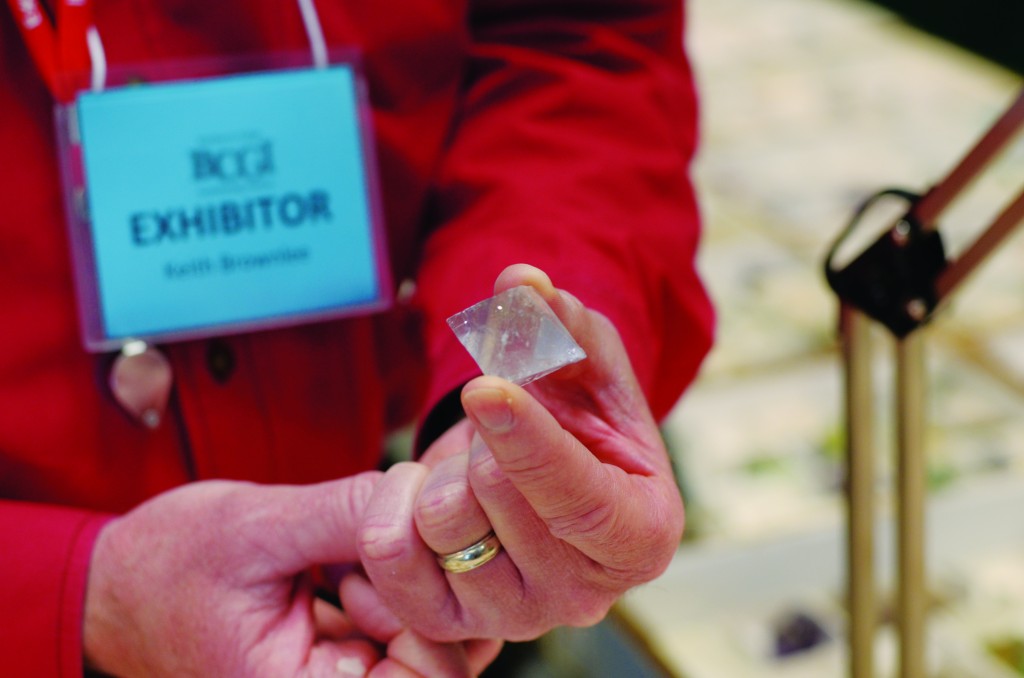 A vendor examines a rock at an exhibit. 