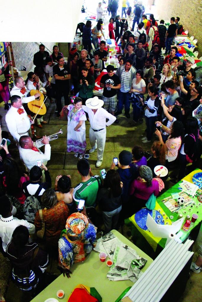 A crowd gathers to watch dancers perform a Mexican folk dance.