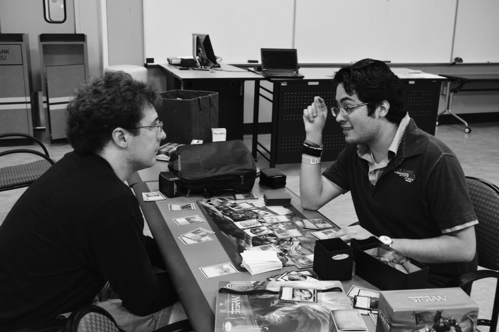     Photo by Marvin Montesinos | Staff Writer     Game club president Ricardo Flores Ruiz (right) teaches Ryan Bogan (left) how to play Magic: The Gathering.