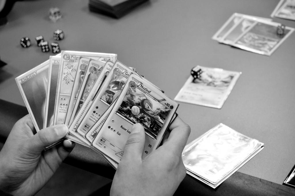 A player holds a hand of Pokémon cards