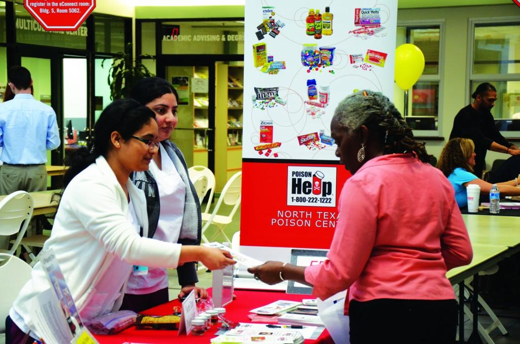 Preeza Karmacharya, a Texas Woman’s University nursing student, hands a pamphlet to visitor Marilyn Cunningham