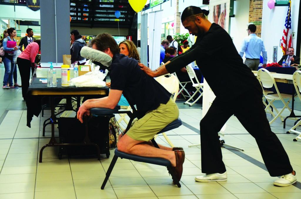 Photos by Travis Baugh | Courier Erron Johnson from Trinity Bodyworks gives an attendee a free massage