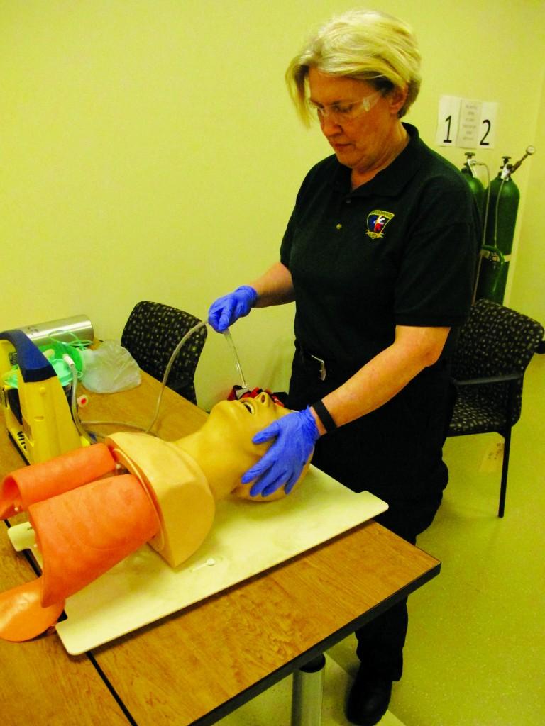 Instructor Robin Price practices suctioning debris from a patient’s mouth as a part of the resuscitation training.
