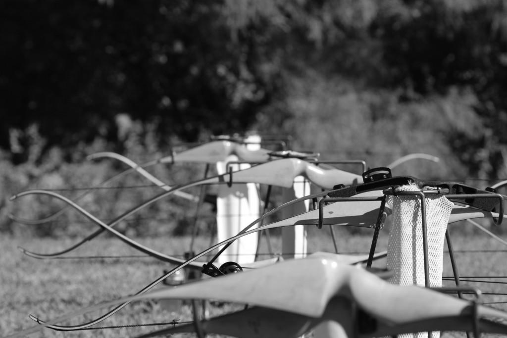 Bows rest on ground quivers after students practice shooting. 