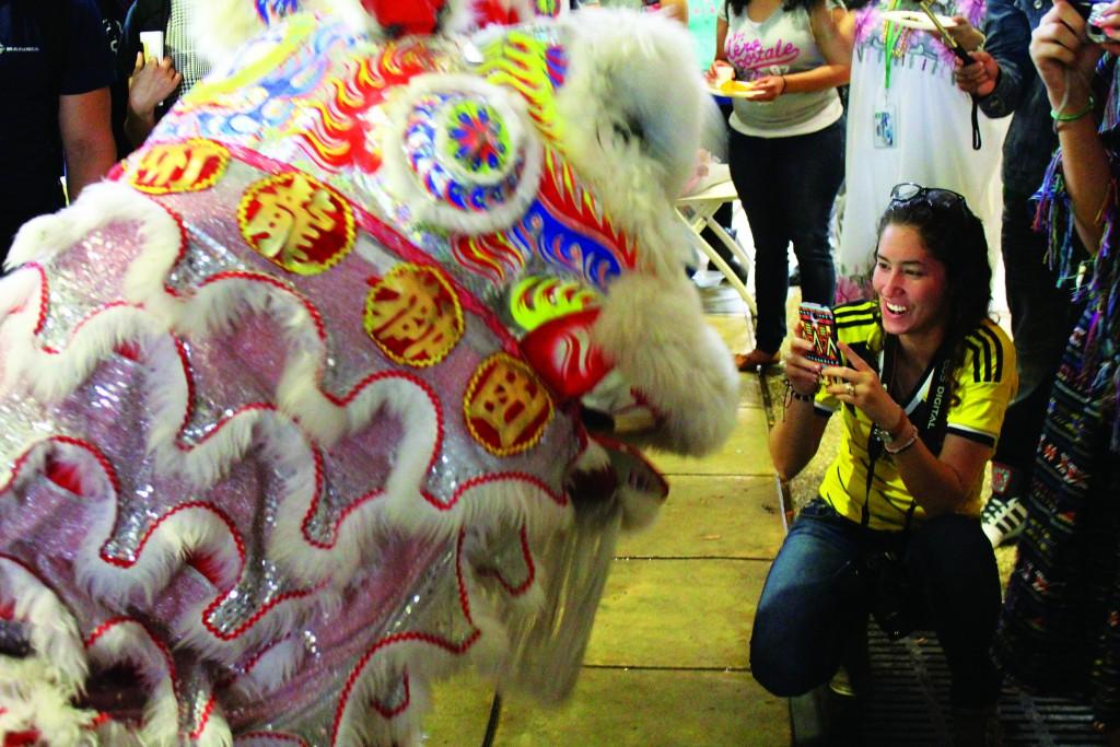 Brigitte Zumaya | Courier Brookhaven College student Vanessa Jaramillo uses her phone to capture the Chinese lion dance.