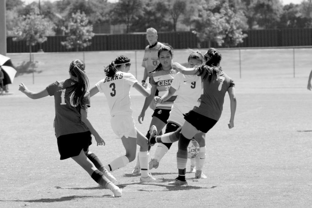 The ball drifts between midfielders Beatrice Aguilar (#9) and Claudia Aguilar (#3) of the Brookhaven Bears and midfielder Lauren Martinez (#33) and defense player Alizah Mendoza (#7) of Cisco College.