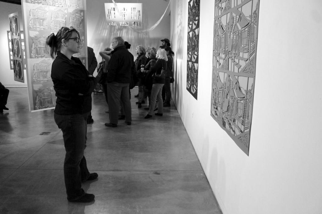 Student Lynette Sykora studies one of Yoo’s prints during the closing reception.