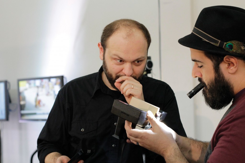 Rodrigue and Armand Kohandani, owner of the Denton Camera Exchange, examine an instant film camera.