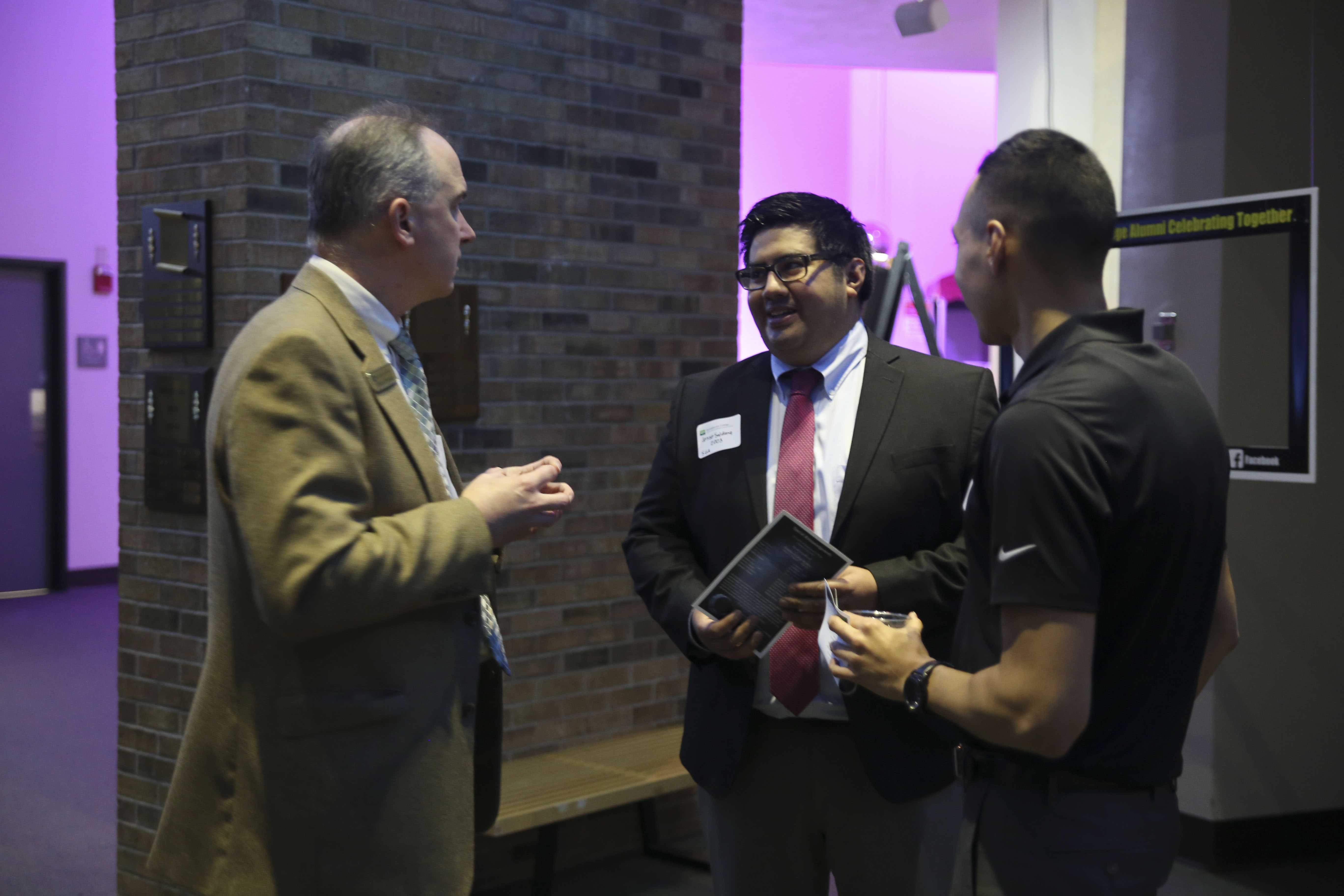 Brookhaven President Thom Chesney speaks to Brookhaven alumnus Jesse Saldana.