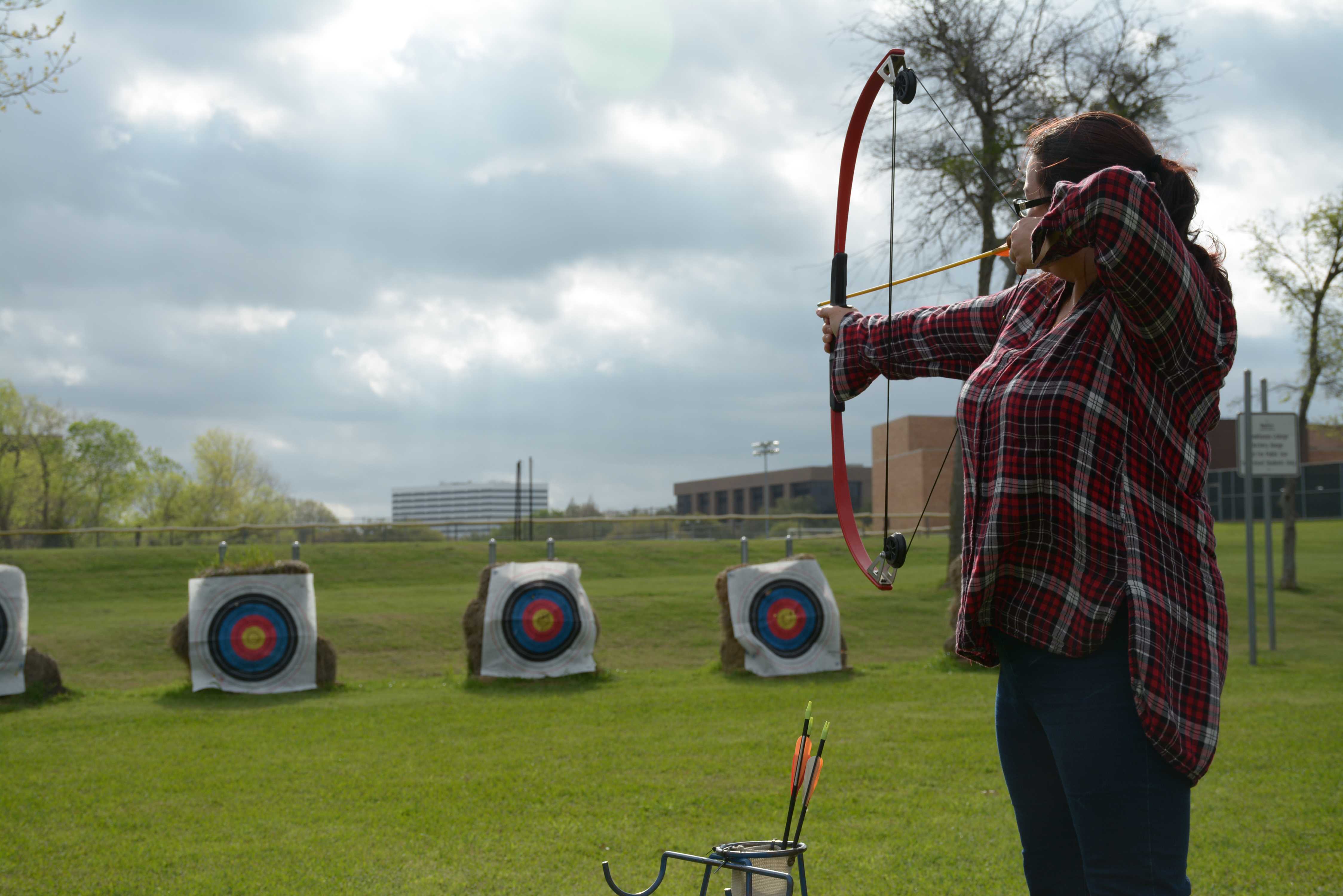  Amy Rogers, a student, prepares to shoot an arrow from her compound bow.
