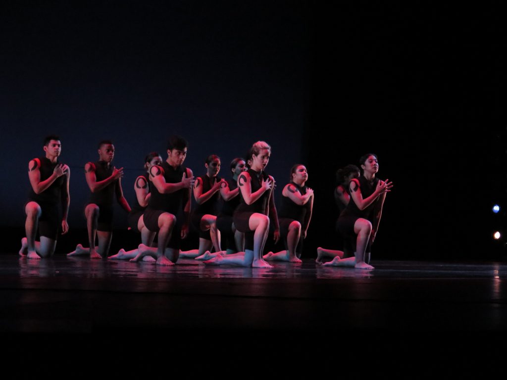 Dance students kneel during a performance to “Strength in serenity.” 