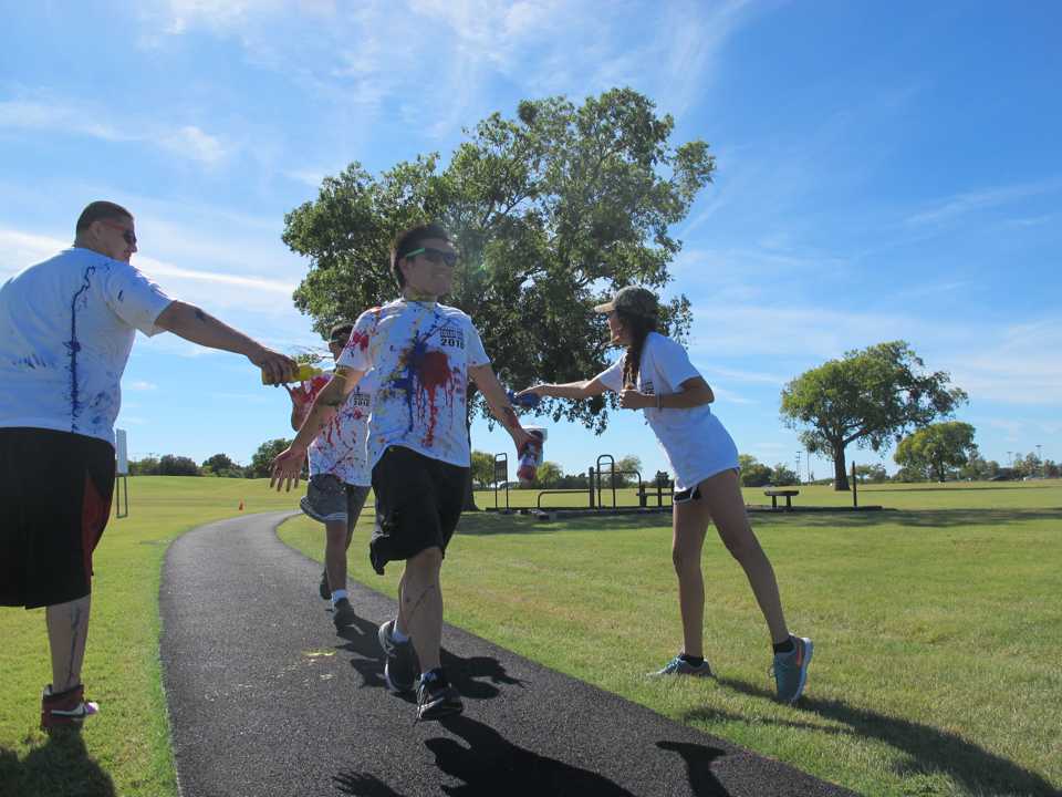 Sonia Agulera and Fernando Sanchez, Student Government Association members, throw paint on runners. 