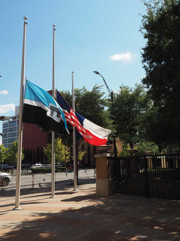 Photo by Jubenal Aguilar The El Centro, U.S. and Texas flags fly at half staff outside the front entrance of El Centro College July 19.