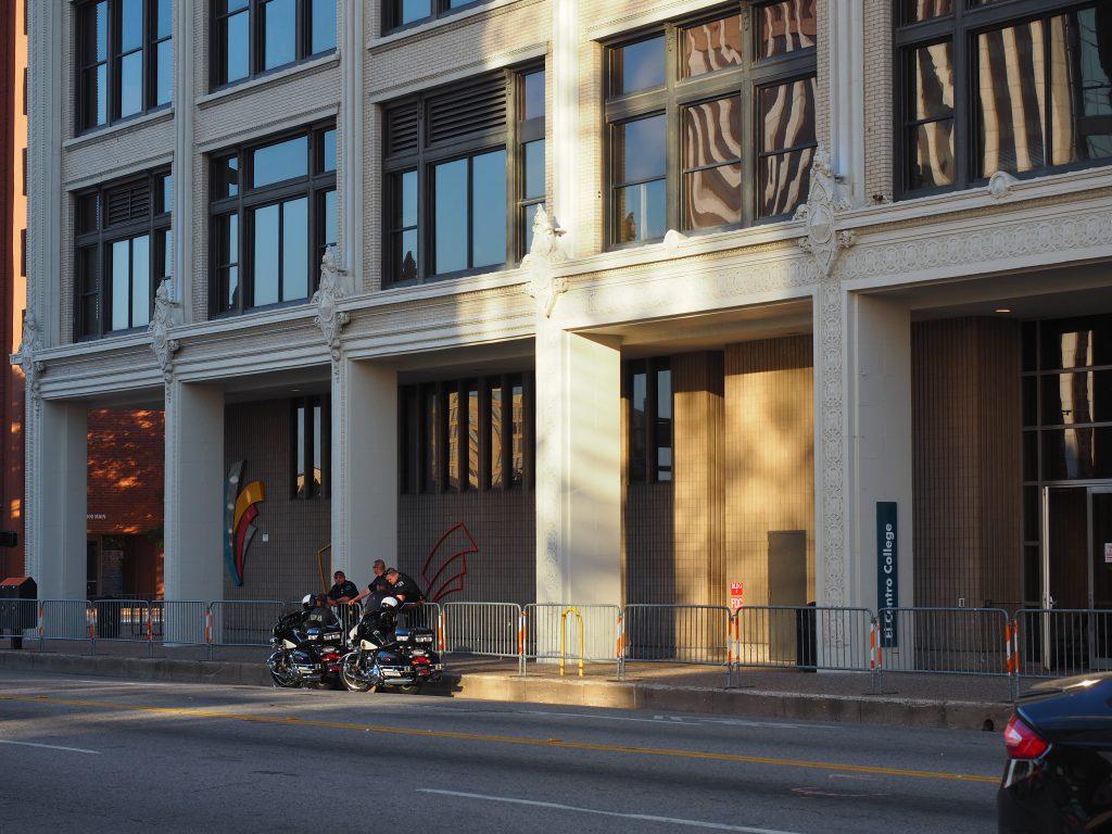 Dallas and El Centro College police officers talk outside the Lamar Street entrance of El Centro July 19. Barricades around the college indicated the building was not open to students, staff and faculty 12 days after the downtown shooting.