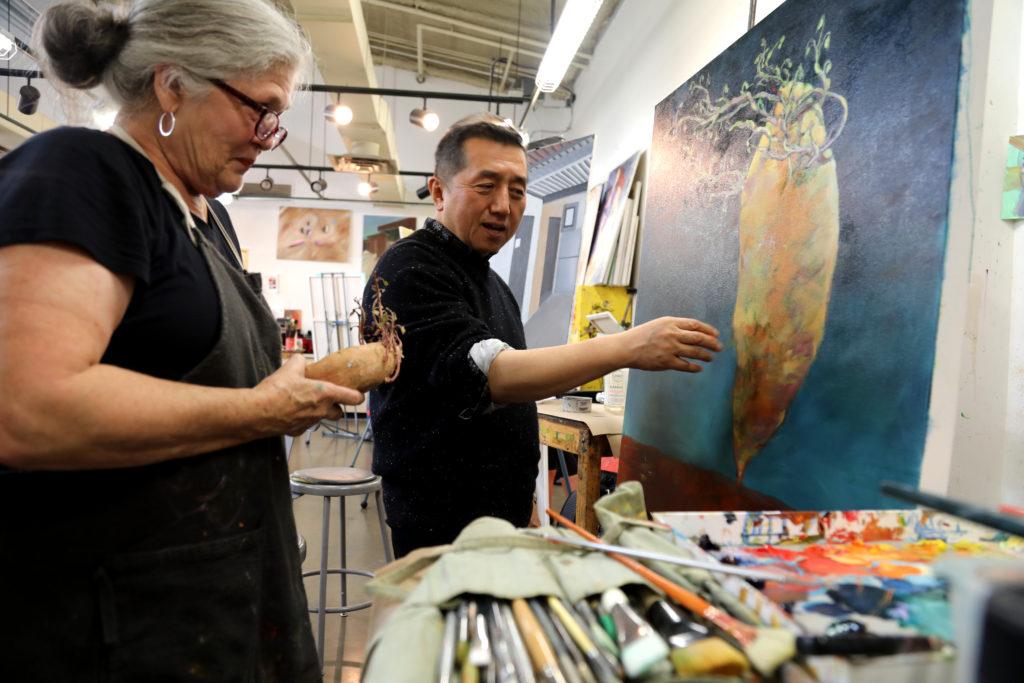 Photos by Jubenal Aguilar | Chong Chu, art professor (right), talks with Nancy Neergaard, a student, about her painting project and what she can do to improve the art piece to render a more realistic interpretation of a potato Nov. 6.