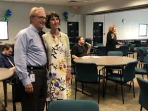 Photo by Jacob Vaughn | David Griggs (left), adjunct professor of criminology, and Carrie Schweitzer, director of sustainability, pose for a photo at her retirement party Aug. 28.