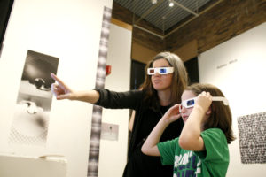 Photo by Matthew Brown | Artist Ashley Whitt and gallery attendee Jack Browning look through 3D glasses at works featured in Whitts exhibition Mind Loop Sept. 6 in the D Building Studio Gallery.