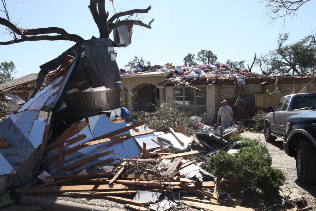 Photo by Malen Blackmon | A resident walks among the aftermath of an EF-3 tornado that swept through Preston Hollow Oct. 23