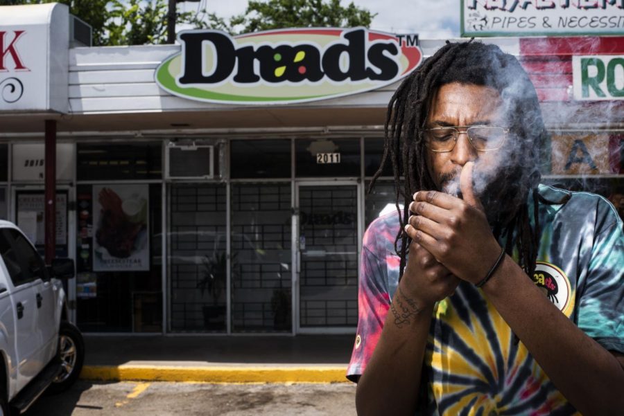 Former Dallas College Brookhaven Campus’ student Malen Blackmon smokes the legal Delta-8 THC strain in front of his new business investment.