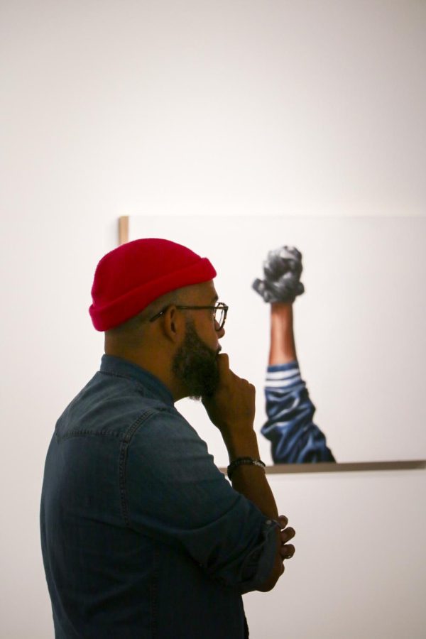 Photo of Jeremy Biggers looking at his art