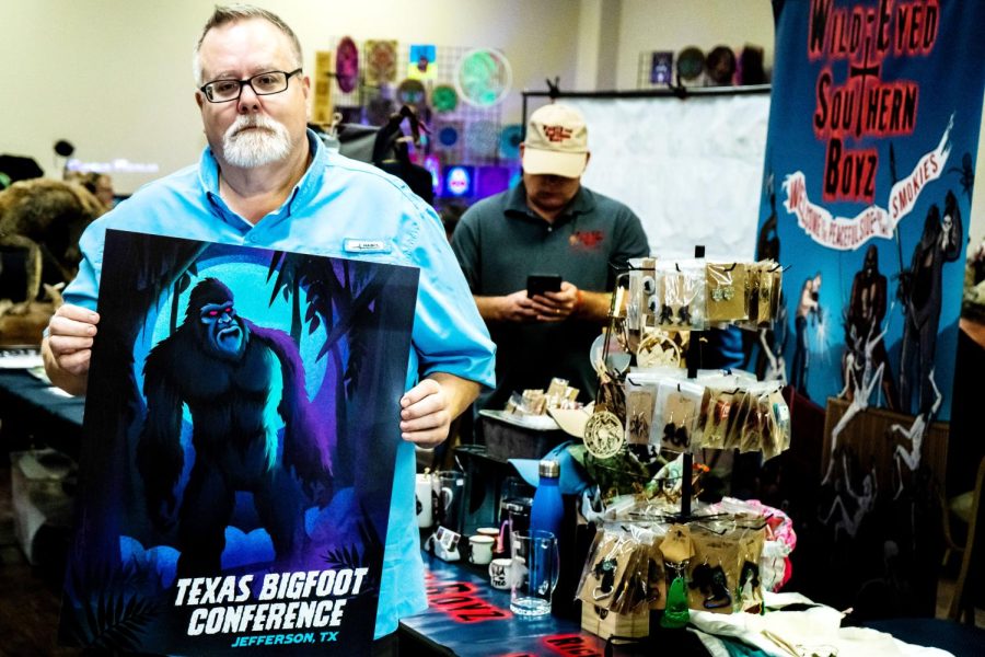 Craig Woolheater posing with the poster for the Texas Bigfoot Conference on Oct. 15 2022.