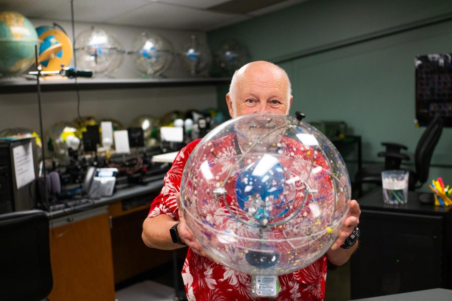 Chaz Hafey, physical sciences lab specialist, looks over a transparent celestial sphere.