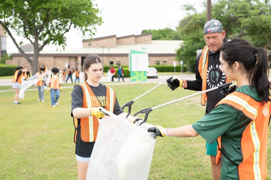 Student Caroline Simpson (left), Jason Hopkins, senior head athletic coach, and student Kelsie Trevino throw away litter at the Brookhaven Campus cleanup on April 18.