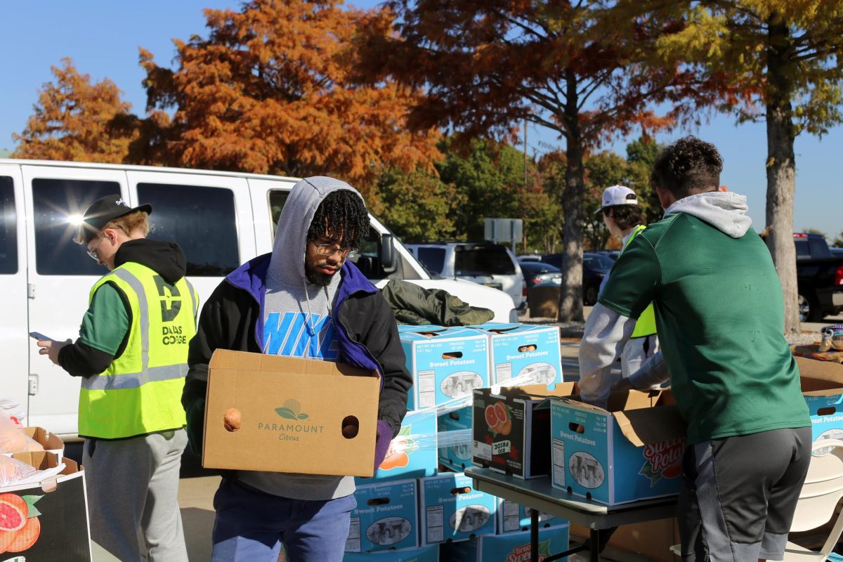 Student carries box of food.