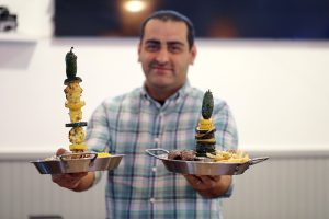 Restaurant owner holds food.