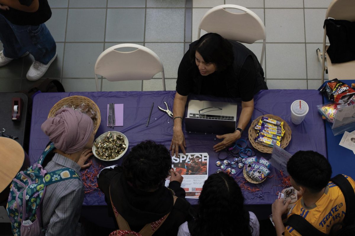 Women sitting at the table talking to a group of students.